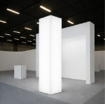 Four-sided backlit SEG column illuminated in a trade show booth environment